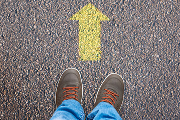 Shoes on road with straight arrow showing forward direction