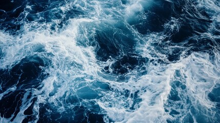 Fototapeta premium Churning waves in deep blue shades show the power of the ocean during a stormy time in the afternoon light