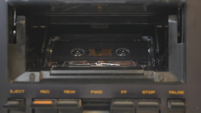Vintage audio cassette tape playing in a retro tape deck