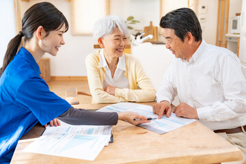 笑顔で相談する高齢夫婦と介護スタッフ