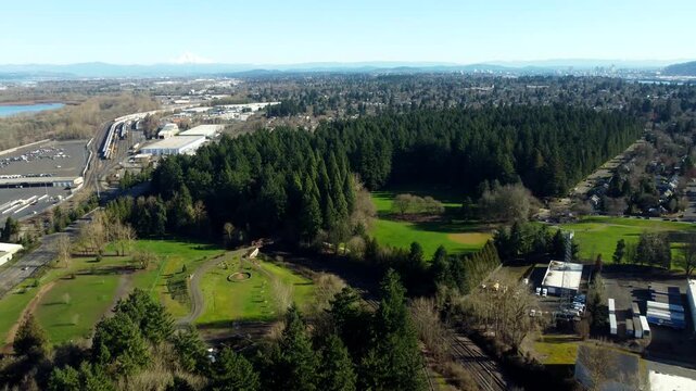 US, Oregon, Portland, 2026-02-11 - Drone view of Pier Park in St Johns, baseball field, trees, disc golf course, with mt hood and portland in the distance, in Winter