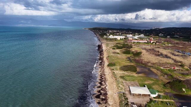 Aerial Coastline View of Acharavi Beach in North Corfu Greece with Stormy Clouds, Seaweed, Rolling Waves and Seaside Resorts