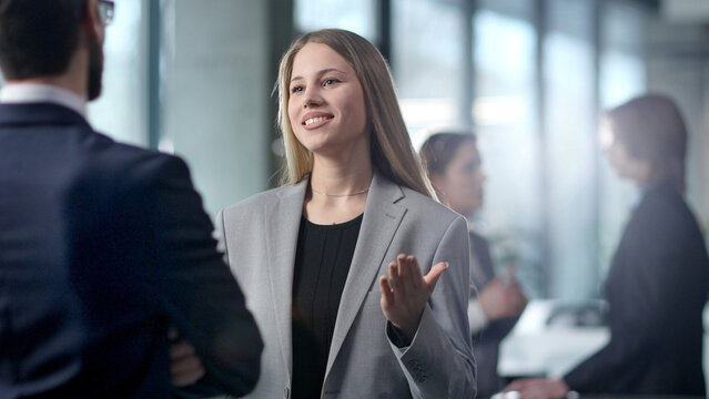 A woman in a business suit is talking to a man in a suit