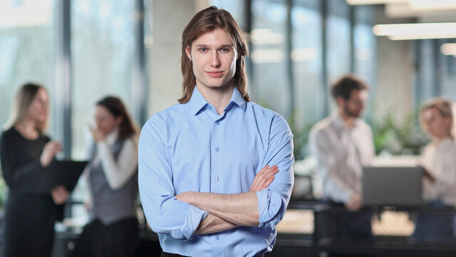 A man in a blue shirt stands in front of a group of people
