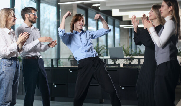 A group of people are clapping and one woman is dancing