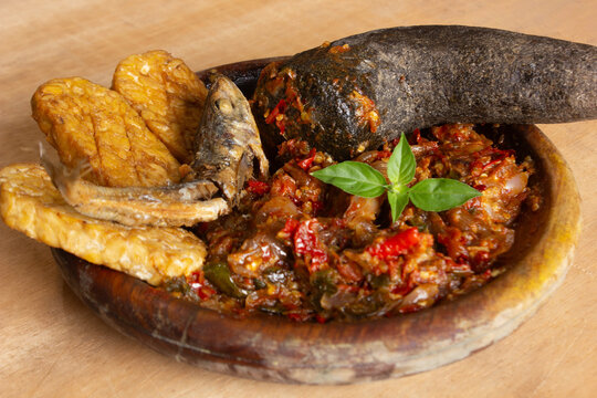 Close-up of sambal ulek served with fried tempeh and salted fish, highlighting bold flavors, rich texture, and authentic Indonesian traditional food pairing.