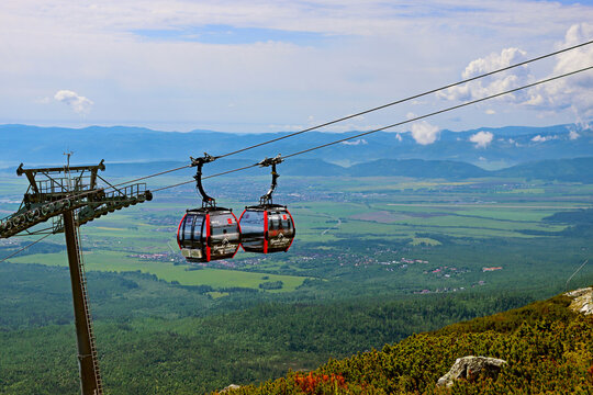 Tatranska Lomnica, Slovakia - May 25, 2024: Cable cars on its way from Skalnate pleso to Lomnicky stit and in the opposite direction with beautiful landscape on background