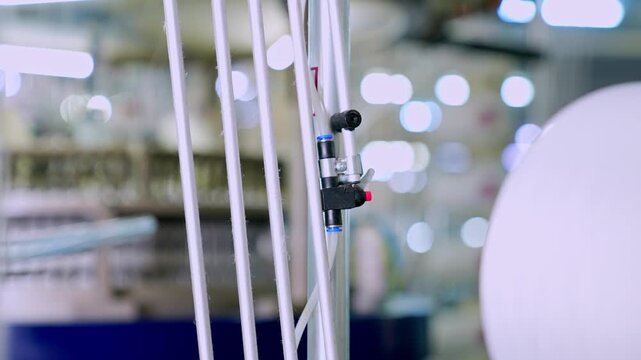 Close up of sensor and machine connection in a modern textile production line. Professional industrial footage reflecting automation, technical control and manufacturing technology.