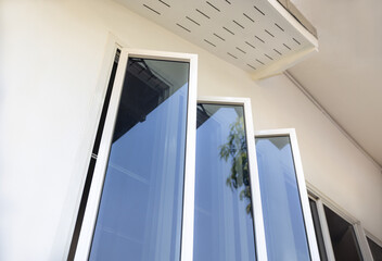 Three panel aluminium casement window stay on white wall.