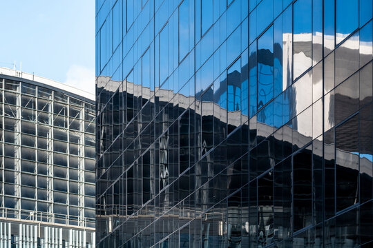Modern corporate building architecture with glass facade reflections in urban office city district showing contemporary exterior design lines and business skyline mood