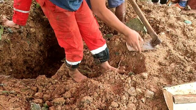Traditional burial process, the gravedigger covers the grave with soil