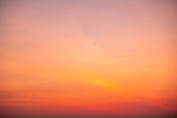 Fototapeta premium Beautiful sunrise sky with vibrant gradient orange and gold colors and soft blue, Clear atmosphere with wispy clouds. Peaceful, perfect for background and copy space, High resolution images