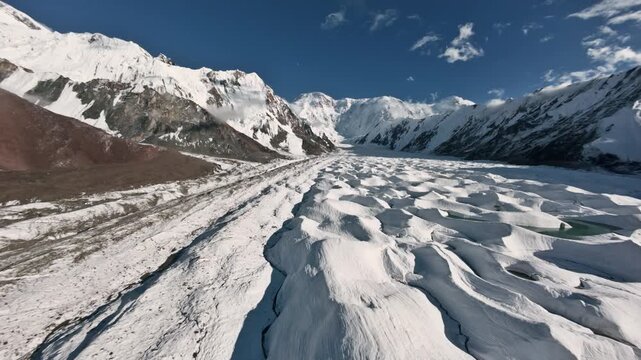 Flying over a glacier toward Pobeda Peak. Incredible views of the Tien Shan Mountains. Nature of Kyrgyzstan. 4K