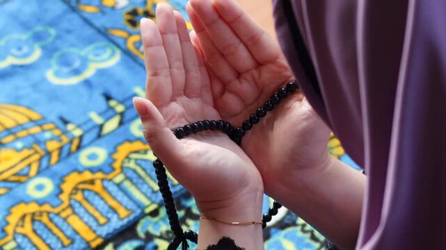 Close up of Muslim woman hands raised in prayer. Female making dua during worship at home. Spiritual devotion, faith and peaceful religious moment concept.