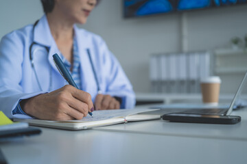 Female Doctor Taking Notes on Medical Report at Desk