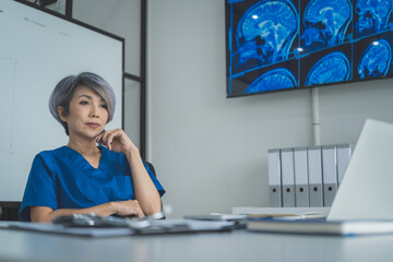 Senior Female Doctor Looking at Brain MRI on Monitor