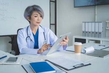 Female Doctor Using Digital Tablet for Medical Records in Clinic