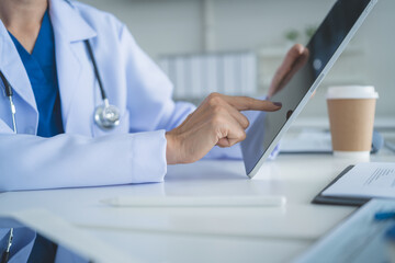 Close Up Doctor Using Tablet Touchscreen in Medical Office