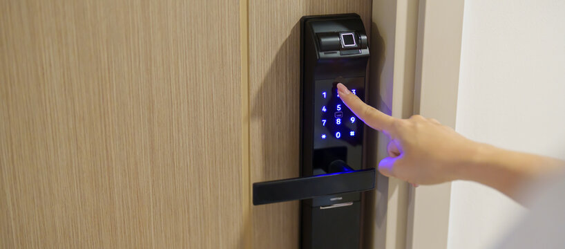 Hand press PIN number for smart digital door lock while open or close the door at home or apartment. NFC Technology, Fingerprint scan, keycard, smartphone and contactless lifestyle concepts