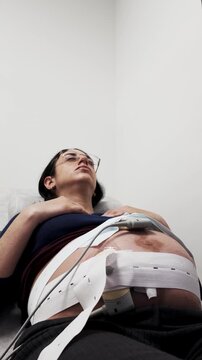 Pregnant woman undergoing cardiotocography fetal monitoring in hospital