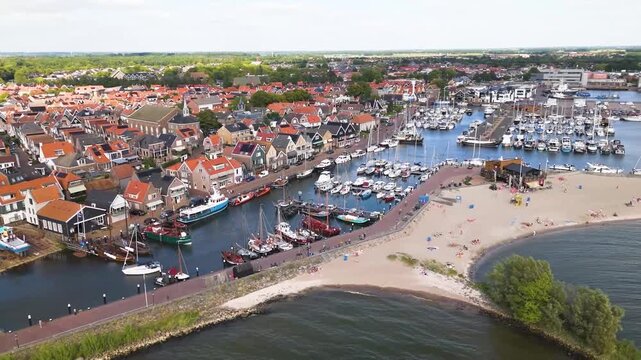 Aerial winter footage of Urk fishing village harbor and lighthouse