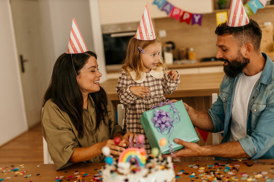 Parents giving precious gift to excited young child