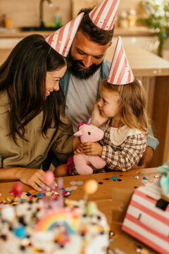Family wearing party hats celebrating daughter's special day