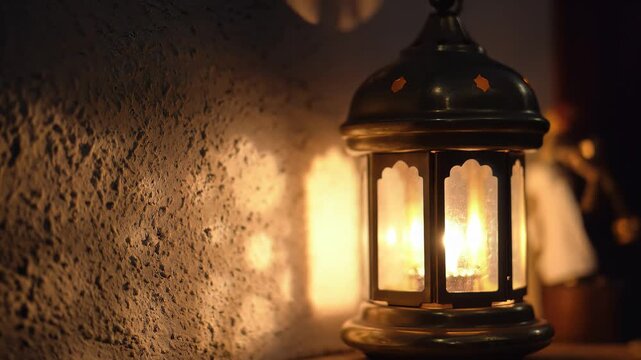 A warm lantern casting soft shadows on a textured wall in a dimly lit room, viewed from a slight angle.