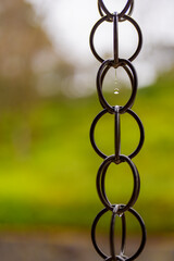 鎖から滴る水滴と緑の背景