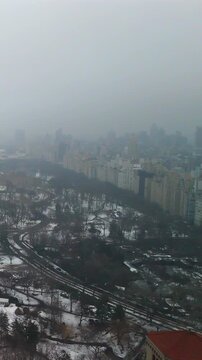 View over Central Park winter snow with foggy Manhattan skyline and rooftops