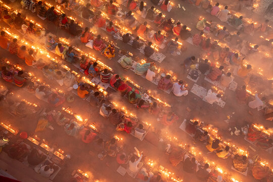 Aerial view of rows of people sitting with lit candles creating a warm glow, illuminating the area in a sea of light, Narayanganj, Dhaka Division, Bangladesh.