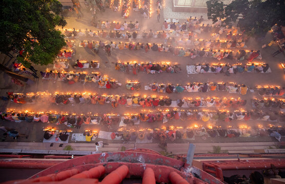 Aerial view of rows of people sitting on the ground with lights, creating a pattern of light and shadow, Narayanganj, Dhaka Division, Bangladesh.