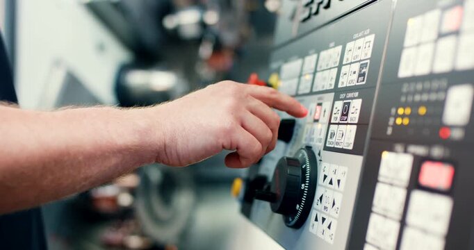 Technician hand operating control panel of industrial CNC machine in factory