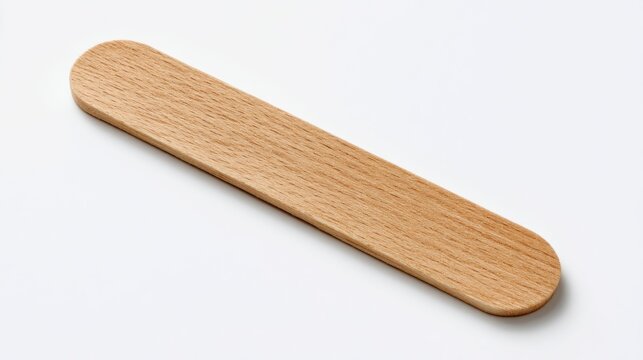 A flat, slender, light-brown wood stick, rounded ends, lies diagonally on a plain white surface