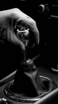 Close-up of a hand shifting gears in a manual transmission car.