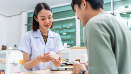 Beautiful asian female pharmacist analyzing about customer symptoms for discussion of the medicine property effect and customer buying pill under prescription order.