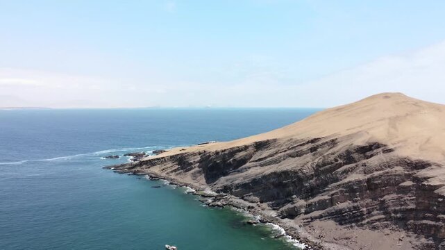 Drone aerial view, blue sea and clear sky blue mountain and boat in Paracas National Park, Peru 4k.