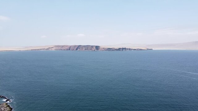 Drone aerial view, red sand beach, big waves and road in desert cliff blue sea clear sky blue. Paracas National Park, Peru 4k