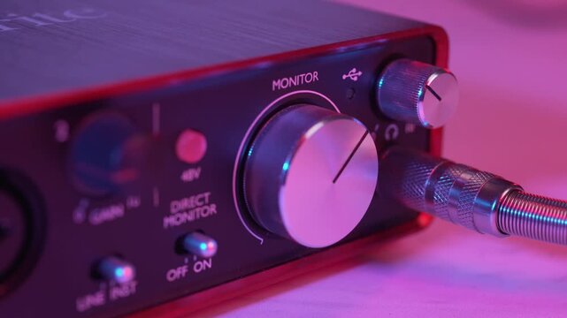 Close-Up of Hand Plugging Headphone Jack into Audio Interface