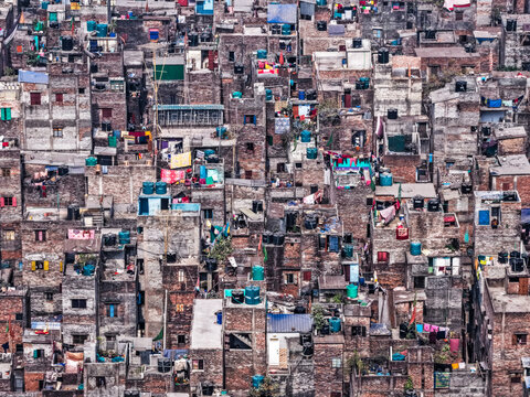 Aerial view of tightly packed, weathered buildings with water tanks create a dense urban tapestry, Dhaka, Dhaka Division, Bangladesh.