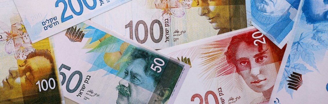 Israel shekel money bills pile on table. Israel banknotes of ILS currency close up.