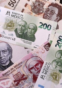 Mexican peso money bills pile on table. Mexico banknotes of MXN currency close up.