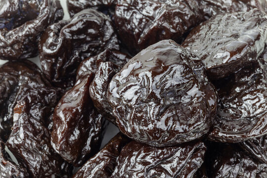 Dry pitted prunes close up background