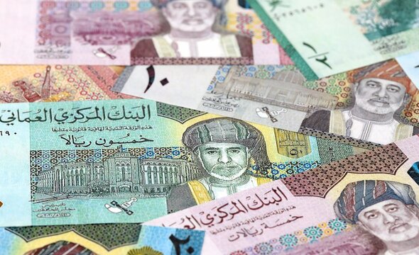 Omani rial money bills pile on table. Oman banknotes of OMR currency close up.