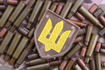 Ukrainian army patch on big amount of shells cartridges from assault rifle bullets
