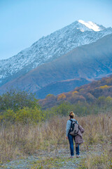 Obraz premium Female Backpacker Hiking Towards Snow Capped Mountain Peak with Copy Space