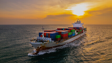 Cargo ships and container ships sail the seas during sunset.