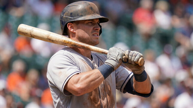 Close-up of a focused professional baseball player with a powerful grip on a wooden bat, tense and ready in a dynamic stance for batting during a game