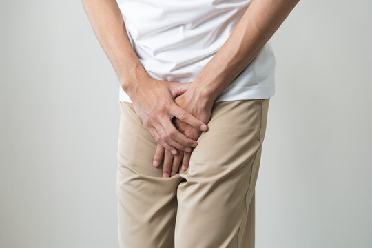 Closeup annoying itch asian man with an itchy his jock and butt, male scratching crotch with his hand, itching groin, male suffering body problem. Health care, hygiene, skin disease, medicine concept.