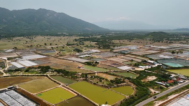 Aerial view of hon khoi salt fields with mountains in the background near nha trang, vietnam, a major producer of sea salt